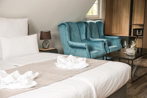 a hotel room with two beds and a blue chair at Hotel Waldeslust in Kurort Altenberg