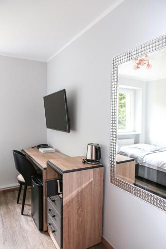 a bedroom with a desk with a mirror and a bed at Hotel Waldeslust in Kurort Altenberg