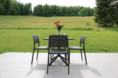 a table and chairs with a vase of flowers on it at Hotel Waldeslust in Kurort Altenberg