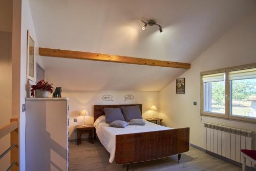 1 dormitorio con 1 cama y nevera. en Gîte les Galets chantants, en Saint-Hilaire-du-Rosier