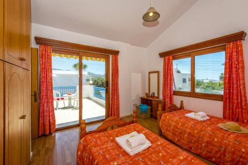 a bedroom with two beds and a view of the ocean at Villa Coralli by Villa Plus in Peyia