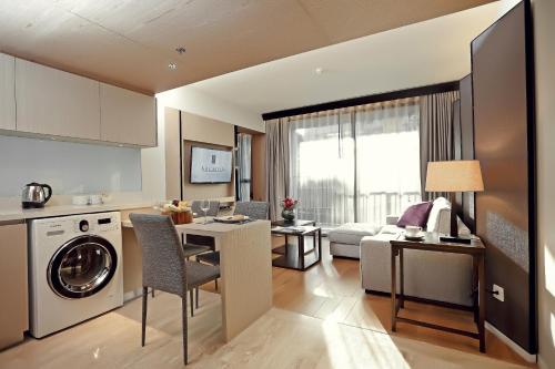 a kitchen and living room with a washer and dryer at Arcadia Suites Bangkok in Bangkok