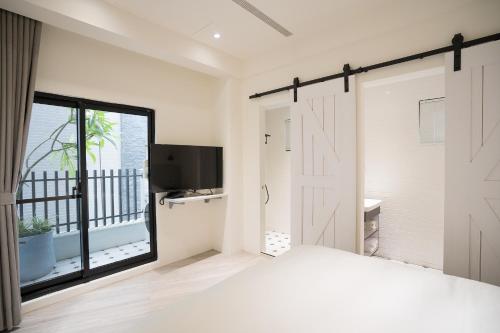 a bedroom with a bed with a sliding barn door at The Way Inn in Taichung