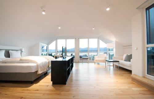 a bedroom with a bed and a large window at Boutique Hotel Aichinger in Nussdorf am Attersee