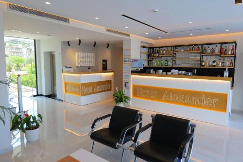 a hotel lobby with two chairs and a hotel adviser counter at Hotel Alexander in Ksamil