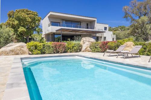 une maison avec une piscine devant une maison dans l'établissement Villa 19, à Zonza
