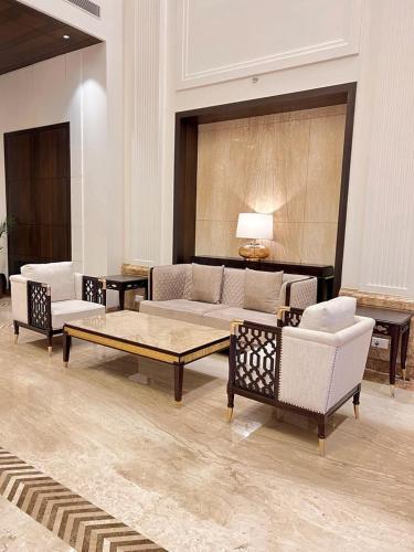 a living room with couches and a coffee table at Palasa Hotel in Muzaffarnagar