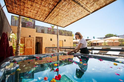 a woman standing in front of a pool of water at Riad Anya & SPA in Marrakech