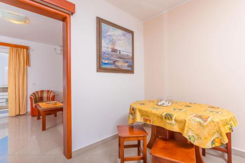 a dining room with a table and a picture on the wall at Rosic Apartments Tivat in Tivat
