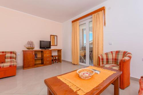 a living room with a table and chairs and a television at Rosic Apartments Tivat in Tivat