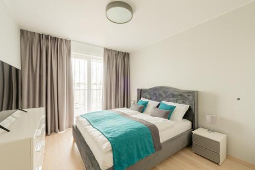 a bedroom with a bed and a desk in it at Apartament Sea & City in Kołobrzeg