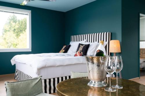 1 dormitorio con 1 cama y 1 mesa con copas de vino en Seeloft - a Sharp Hotel, en Herrliberg