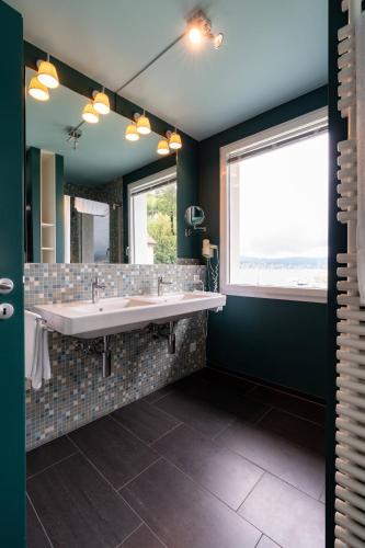 a bathroom with a large sink and a large window at Seeloft - a Sharp Hotel in Herrliberg