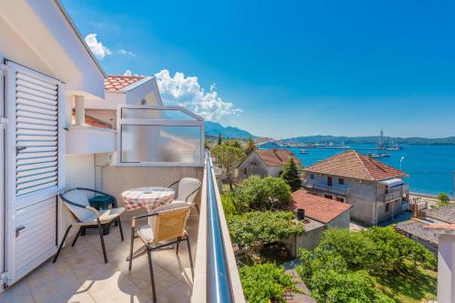 a balcony with chairs and a table and a view of the water at Rosic Apartments Tivat in Tivat