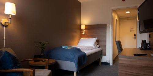 um quarto de hotel com uma cama e um sofá em Thon Partner Hotel Backlund em Levanger