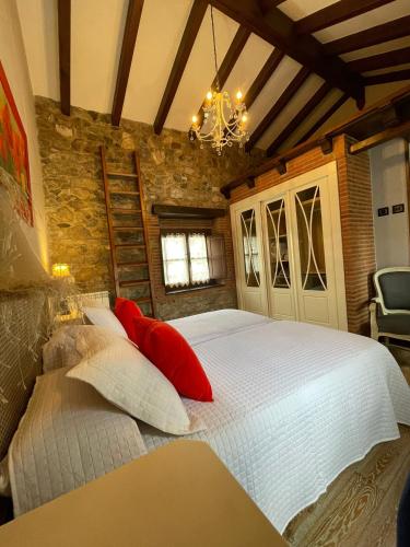 a bedroom with a large white bed with red pillows at Apartamento del s XVI en el casco histórico de Luanco in Luanco