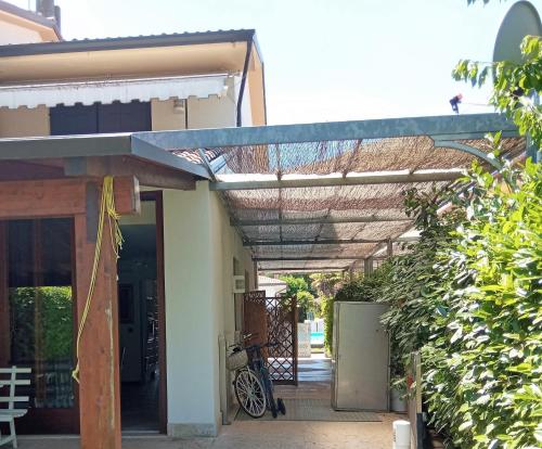 awning over the entry to a house with a bicycle under it at Luxury Villa Duna Verde in Duna Verde