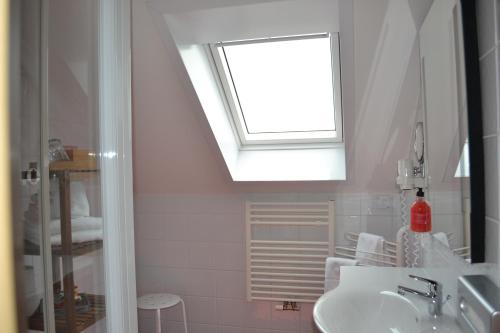 ein Bad mit einem Waschbecken und einem Fenster in der Unterkunft Hotel Villa Rosa in Gamlitz