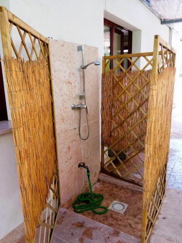 a shower with a hose next to a wall at Luxury Villa Duna Verde in Duna Verde