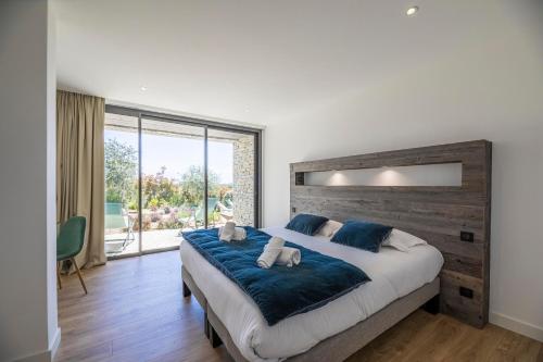 une chambre avec un grand lit et une grande fenêtre dans l'établissement Villa 20, à Sainte-Lucie de Porto-Vecchio