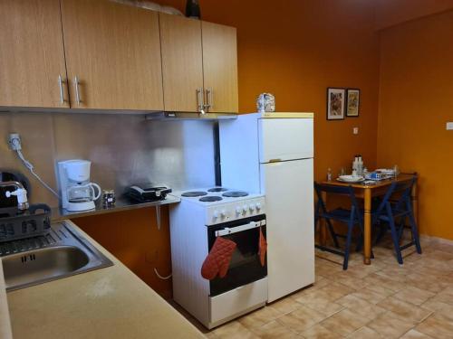 a kitchen with a stove and a refrigerator and a table at Seaside Apartment in Xilokastro 2 in Xylokastro