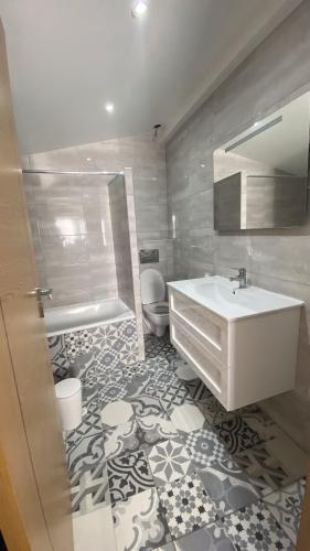 a bathroom with a sink and a toilet and a tub at Casa Malpique in Albufeira