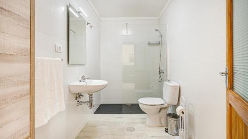 a white bathroom with a toilet and a sink at VALLES DE ORTEGA 6 in Valles de Ortega