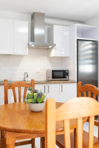 a kitchen with a wooden table with a bowl of greens on it at VALLES DE ORTEGA 6 in Valles de Ortega