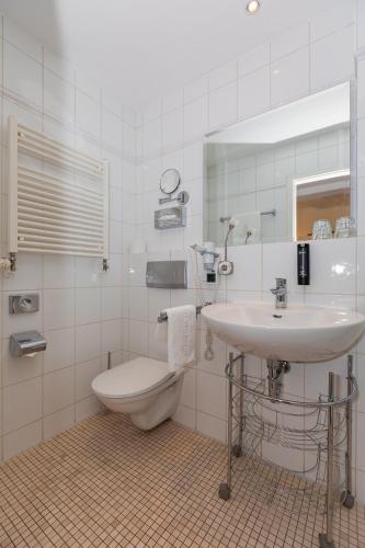 a bathroom with a sink and a toilet and a mirror at Hotel Zum Bär in Quedlinburg