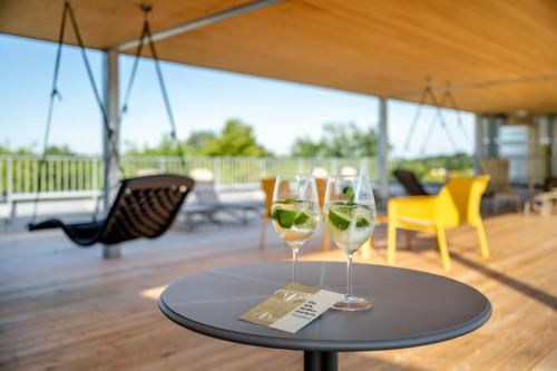 two glasses of wine sitting on a table at Hotel FrechDachs in Bad Füssing