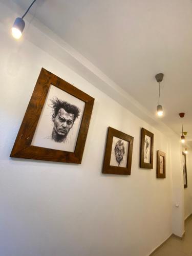 a group of framed photographs on a wall at ZANI Hostel in Prizren