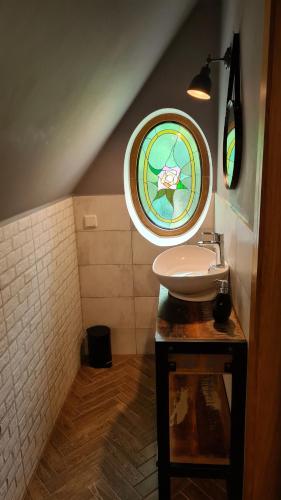 a bathroom with a sink and a stained glass window at Chata w Stołowych in Łęzyce
