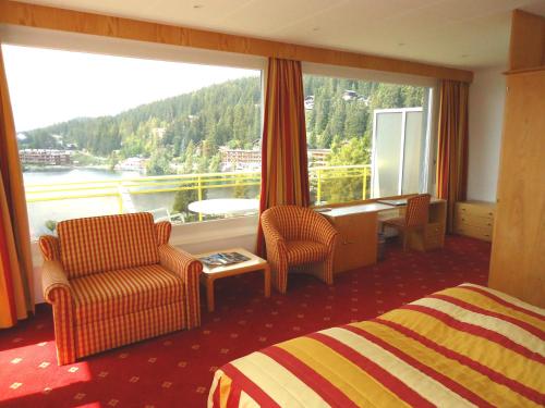 a hotel room with a bed and a large window at Grand Hôtel du Parc in Crans-Montana