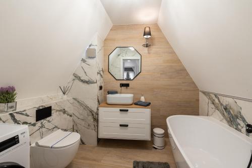 a bathroom with a white toilet and a sink at Szafir Apartament in Kołobrzeg