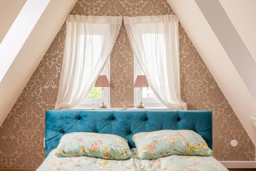 niebieską kanapę w pokoju z oknem w obiekcie Szafir Apartament w Kołobrzegu