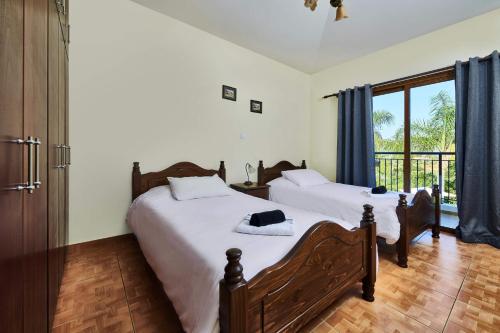 a bedroom with two beds and a large window at Villa Yiolani by Villa Plus in Lachi