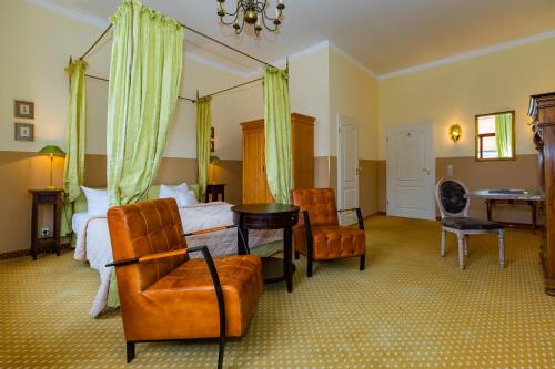 a bedroom with a bed and a desk and chairs at Hotel Zum Bär in Quedlinburg