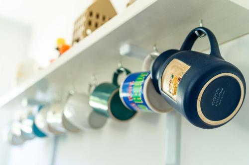 a bunch of coffee cups hanging on a shelf at Apartment Laurel Leaf in Lovorno