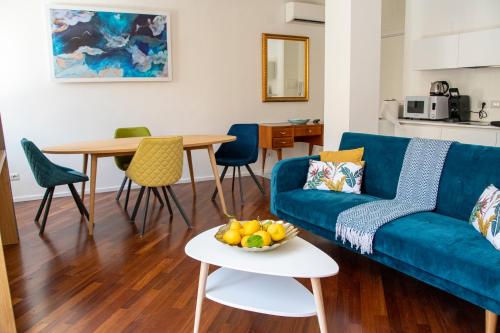 a living room with a blue couch and a table at Castalia Apartments & Rooms Duomo Taormina in Taormina