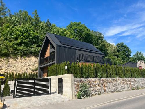a black house with a black roof at Dom z basenem Bałtów 22 in Bałtów