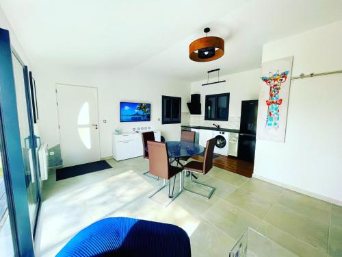 a living room with a table and a kitchen at Le Photinia in Le Bugue