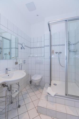 a bathroom with a shower and a sink and a toilet at Hotel Zum Bär in Quedlinburg