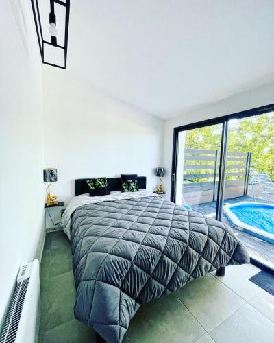 - une chambre avec un grand lit et une piscine dans l'établissement Le Photinia, au Bugue