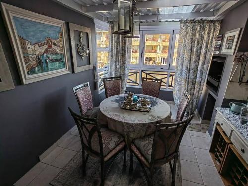 a dining room with a table and chairs and a window at Marina La Vie in Jeffreys Bay