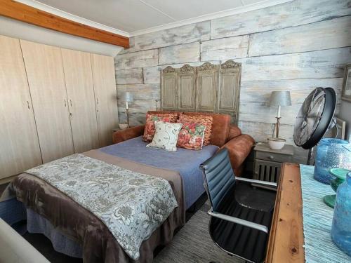 a bedroom with a bed and a wooden wall at Marina La Vie in Jeffreys Bay