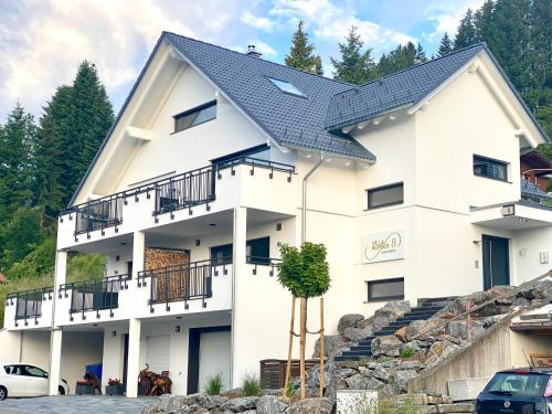 een wit huis met een zwart dak bij Villa Number 8 in Feldberg