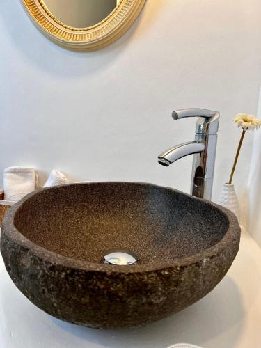 a stone sink in a bathroom with a mirror at Casa Bianca of Kea in Melissaki