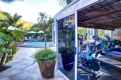 a house with a bike parked next to a swimming pool at Cinnamon Boutique Guest House in Wilderness