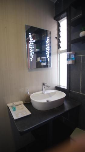 y baño con lavabo blanco y espejo. en NS Villa en Pokhara