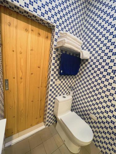 baño con aseo y azulejos azules y blancos en 鄉間小路 Home 備有專屬停車場, en Zhushan